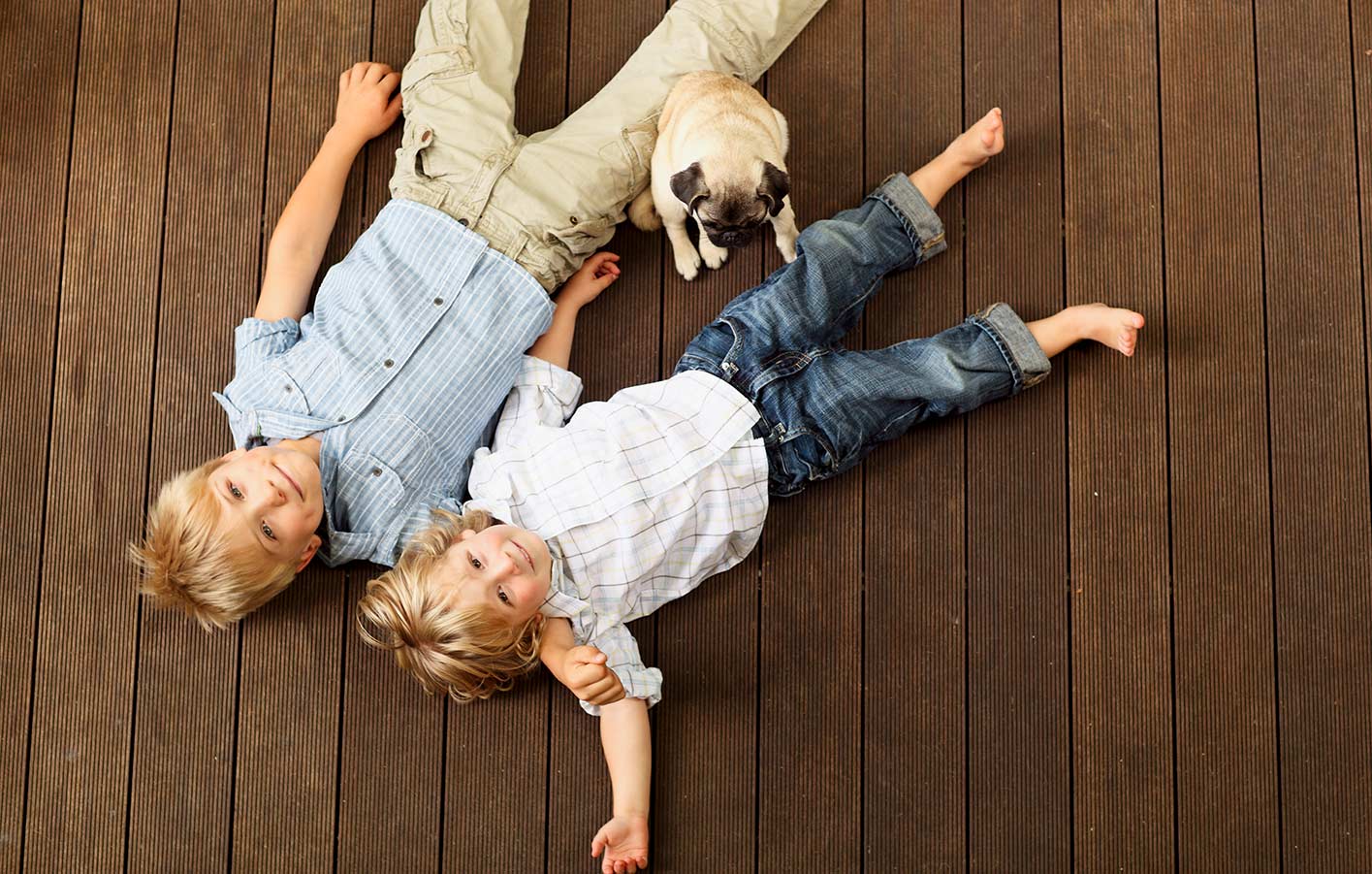 Kinder liegen auf einer Terrasse aus Holz
